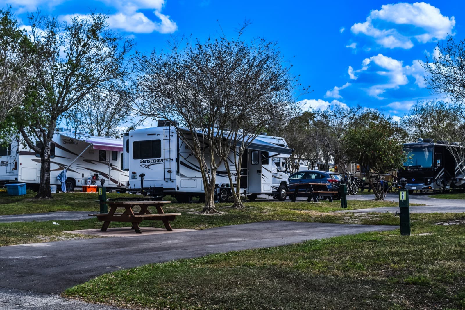 RV sites with picnic tables at a campground on a sunny day