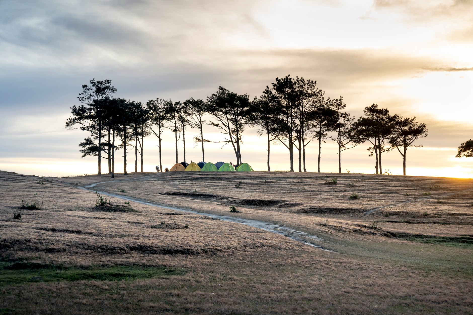 Tents pitched on a ridge at sunrise, the exploring stage of buying a campground
